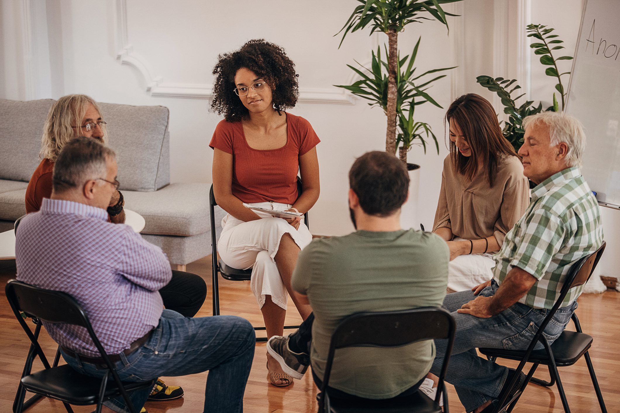 Adults sitting in a close circle during a group therapy session